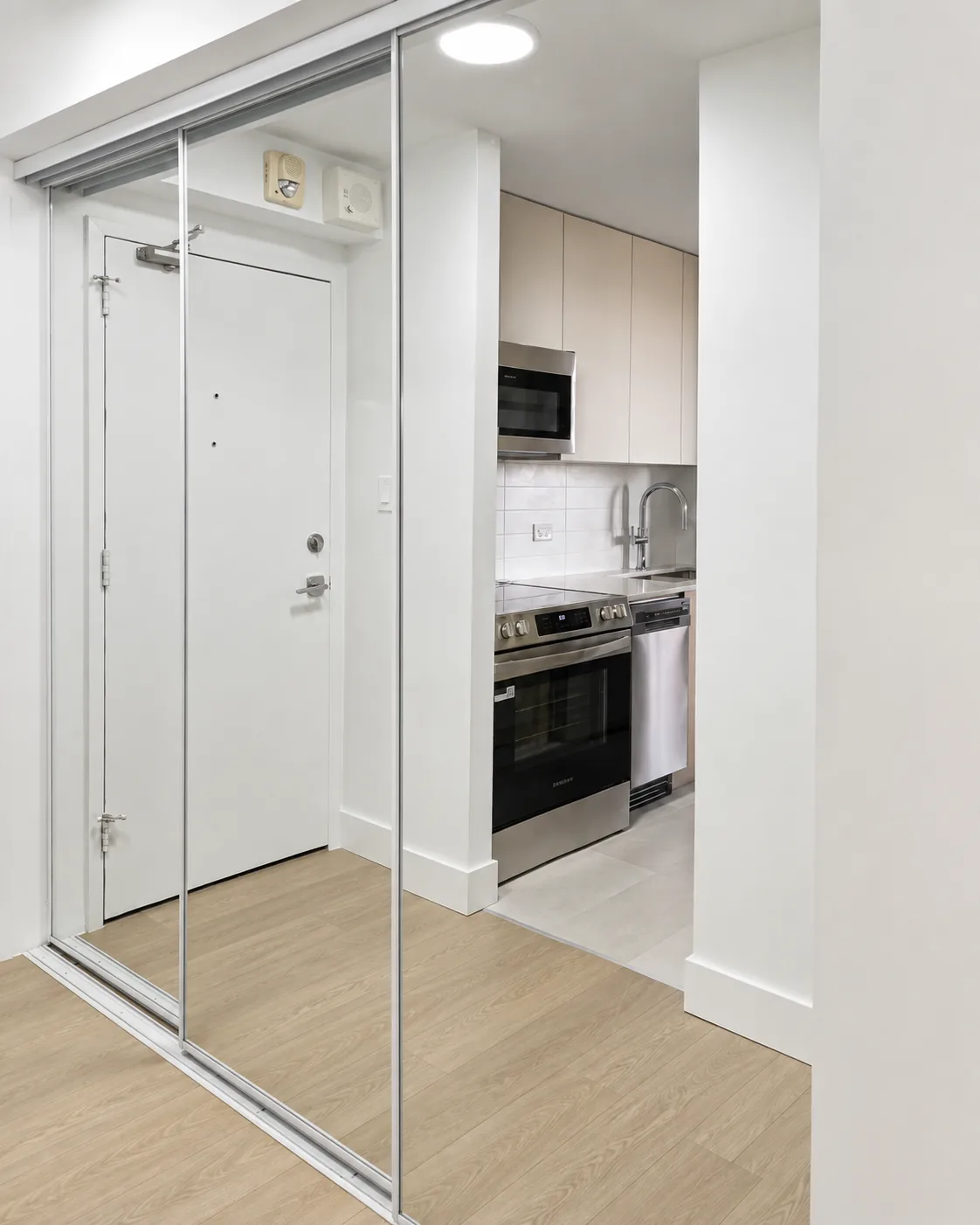 Mirrored sliding closet doors beside a kitchen entry