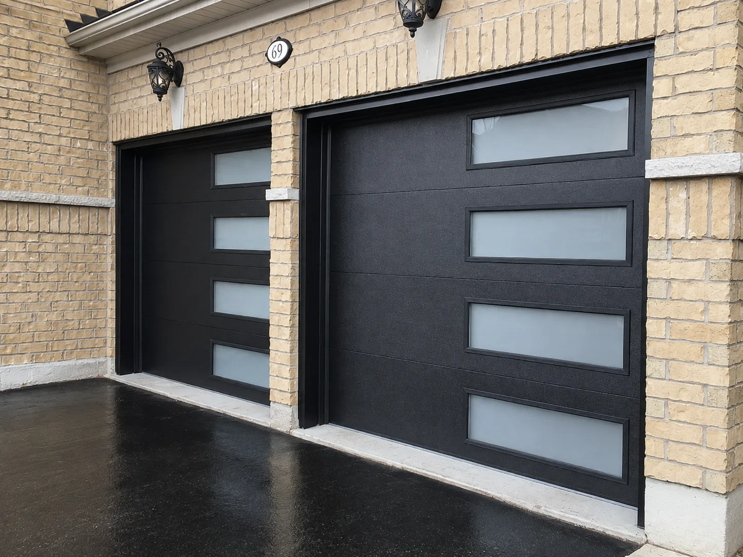 Two black garage doors with vertical glazing on a brick facade
