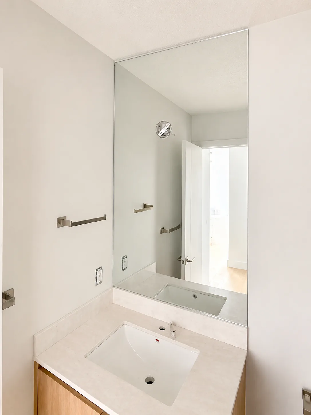 Frameless vanity mirror above a wood vanity