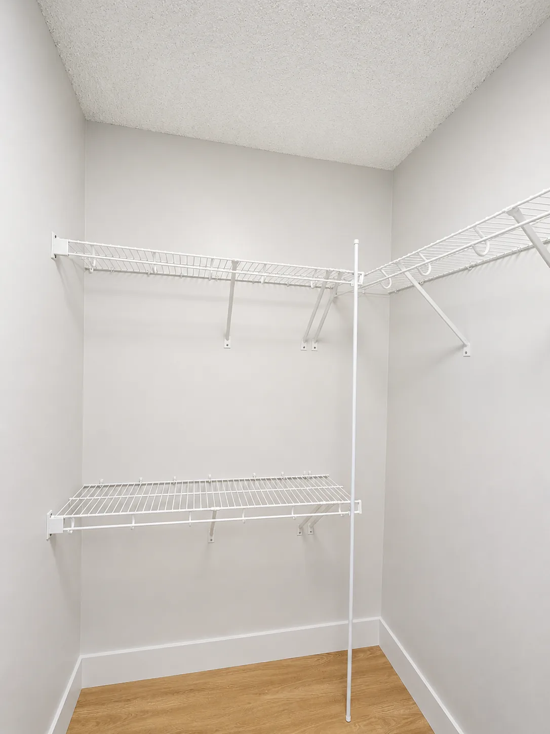 Wire closet shelving with hang rods in a corner layout
