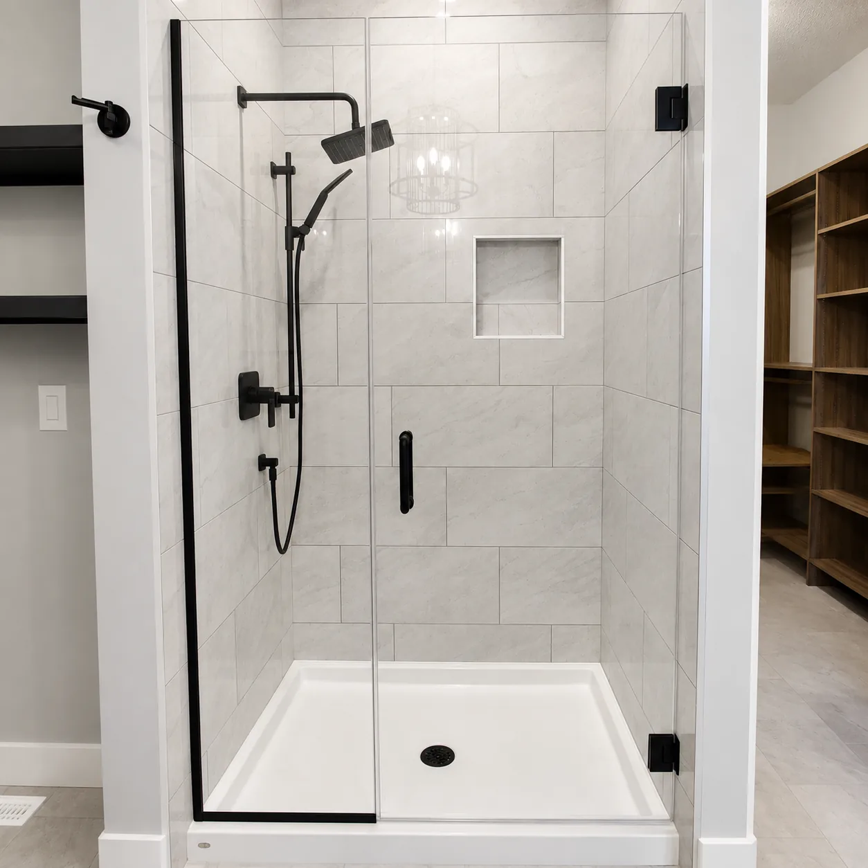 Frameless hinged shower door with black hardware and white tile